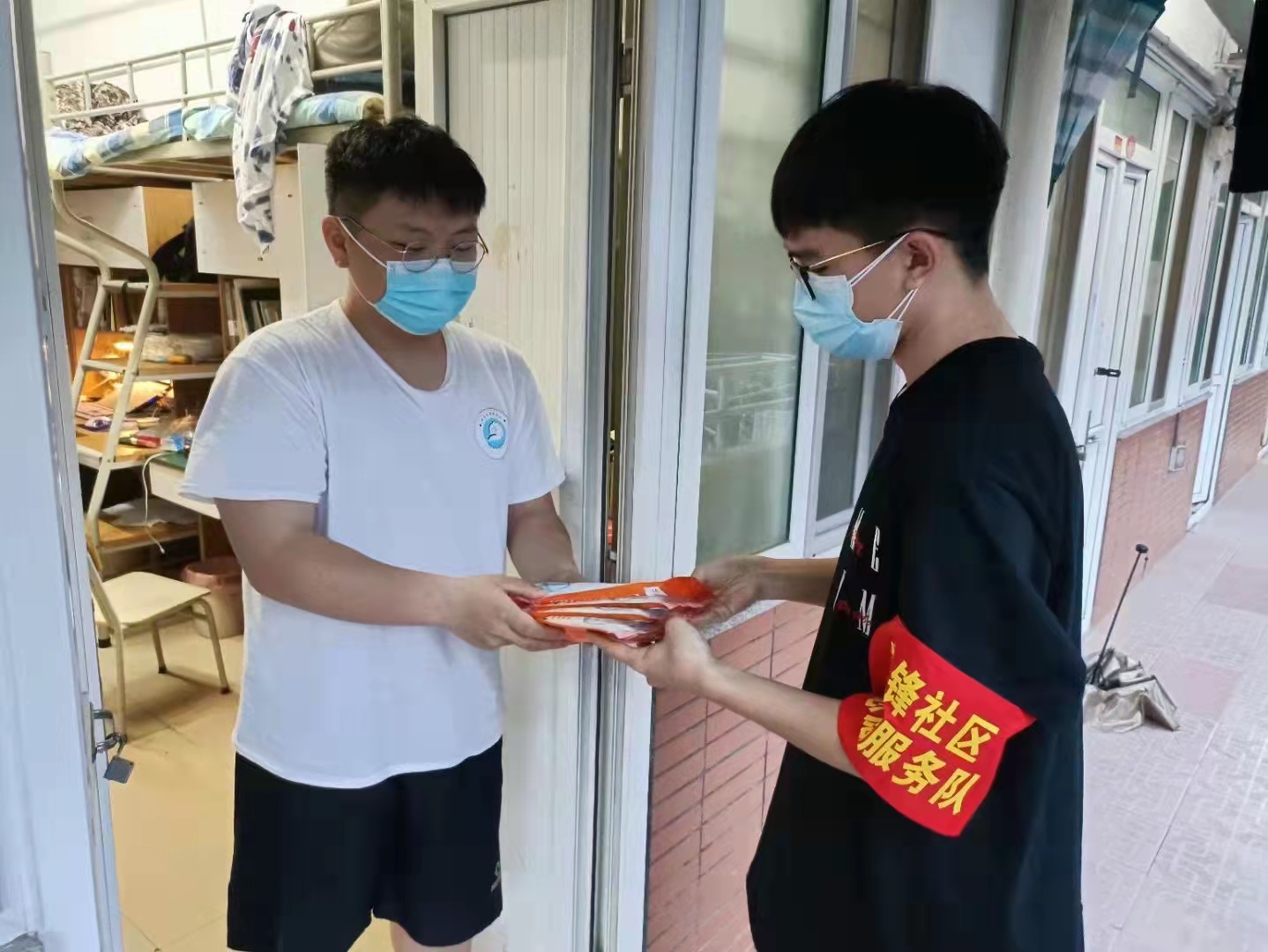 青年学生参与楼栋志愿服务,为同学配送物资.jpg